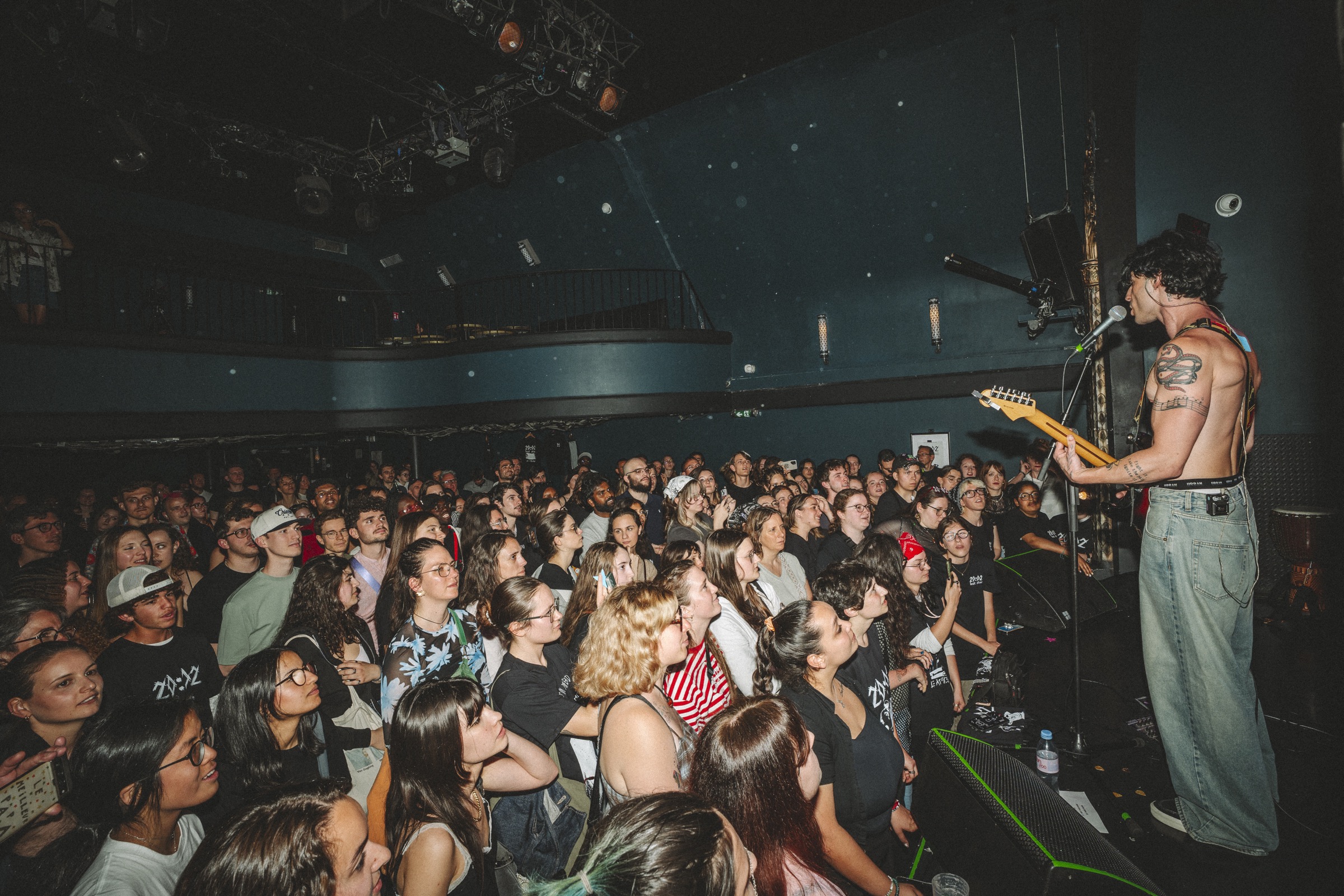 Axel Gregorcik on stage indoors, crowd in the foreground.